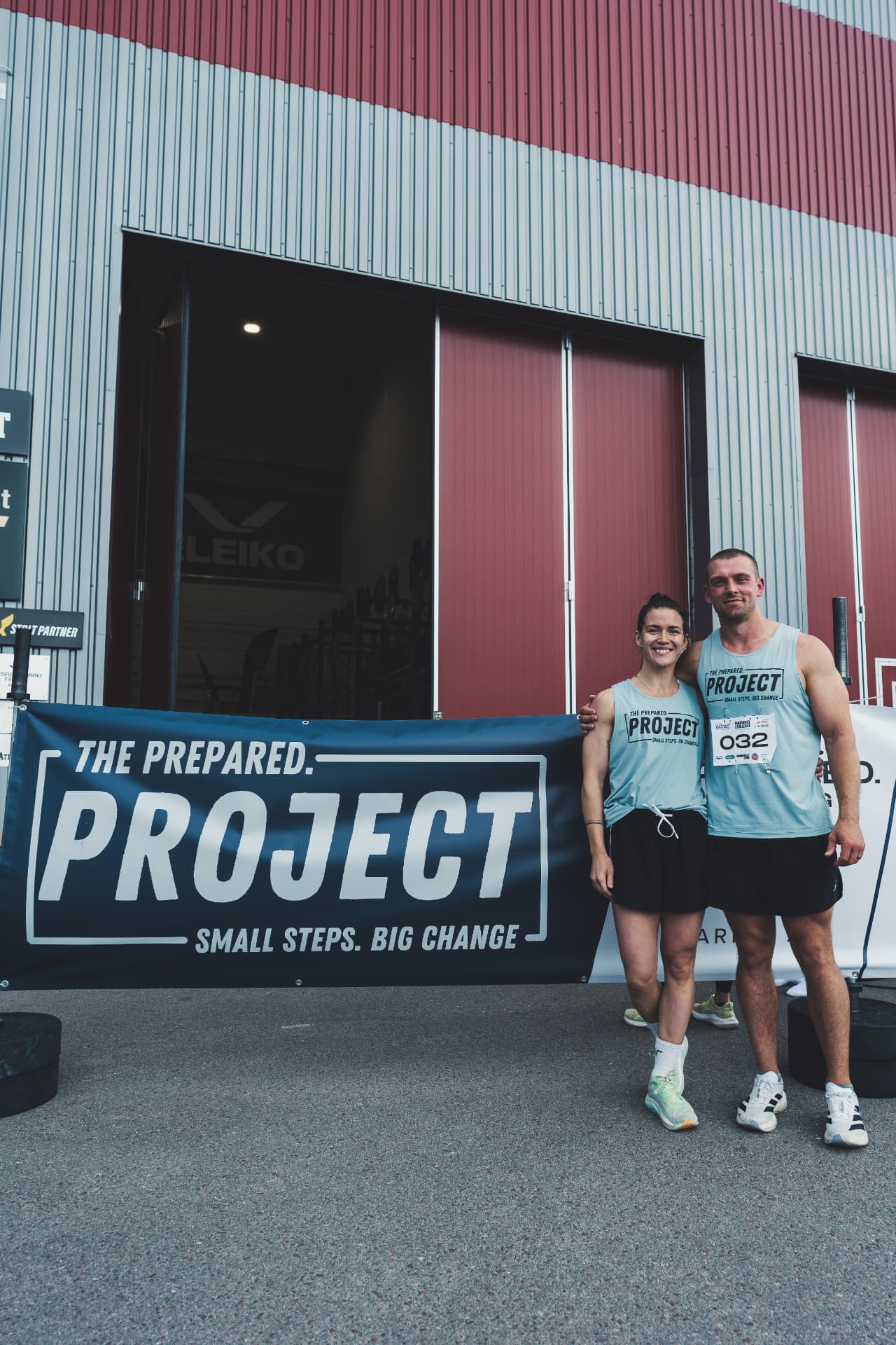 Phil and Mia Hesketh in race kit standing in front of The Prepared Project banner